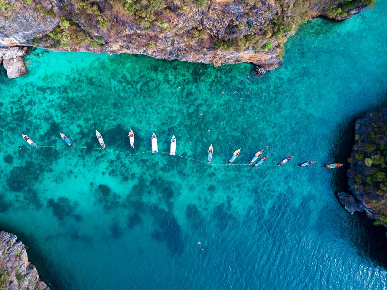 Barcos nas águas transparentes e cristalinas de Koh Phi Phi na Tailândia.