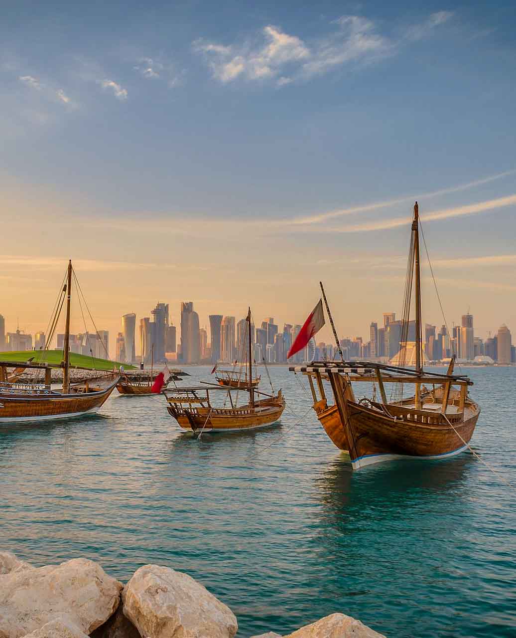 Doha e o pôr do sol com vista dos prédios e barco tradicional - passeios em Doha